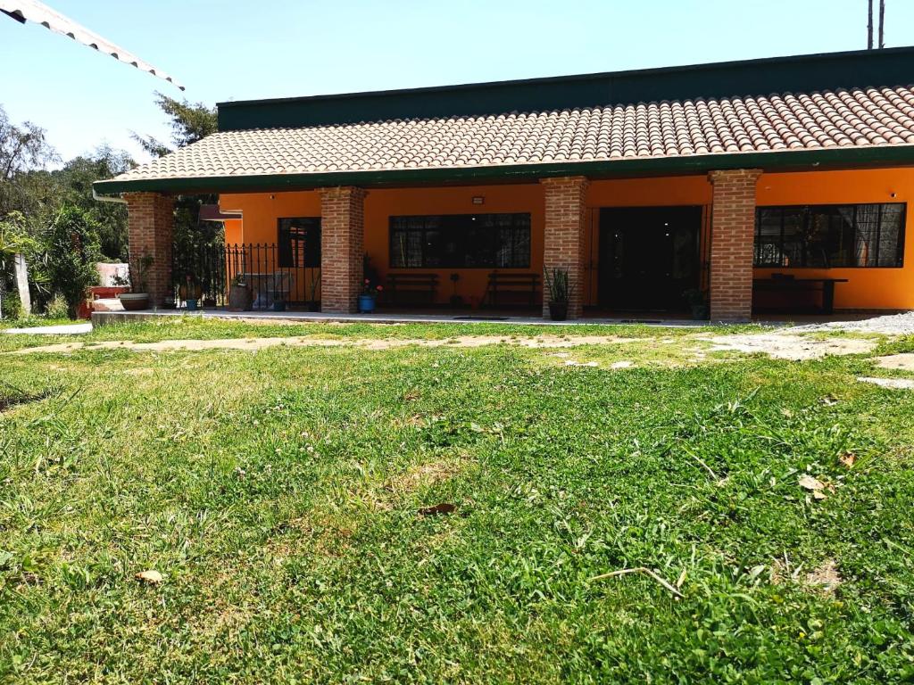 une maison orange avec une pelouse devant elle dans l'établissement Casa de campo en Teziutlán, Puebla., à Teziutlán