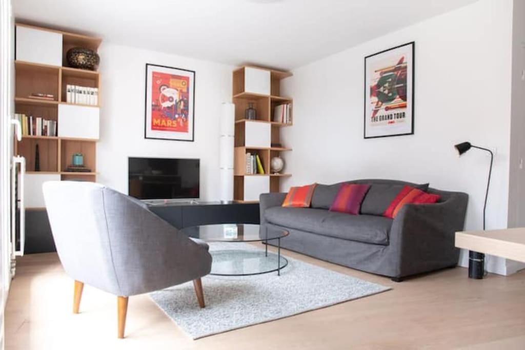 un salon avec un canapé et une table dans l'établissement Le QUAI Paris-Boulogne-île Saint Germain au calme avec parking, à Boulogne-Billancourt