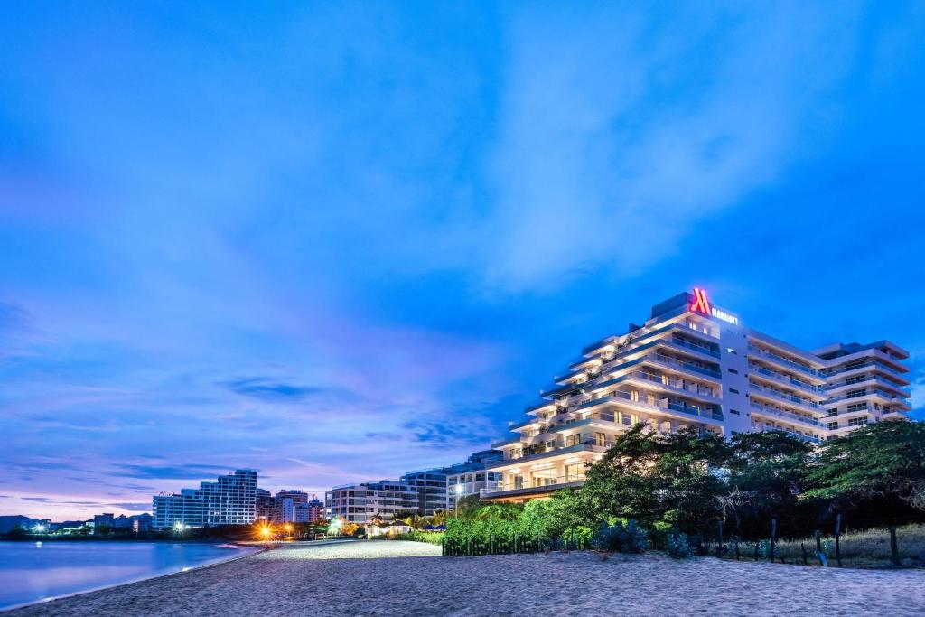 a large building with a flag on top of it at Santa Marta Marriott Resort Playa Dormida in Santa Marta