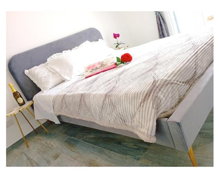 a white bed with a red rose on top of it at Chic in Fiumicino