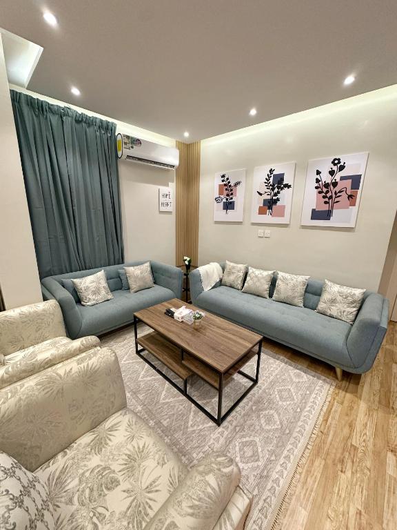 106 A شقة جميلة بغرفتين نوم ودخول ذاتي في الرياض: غرفة معيشة مع أرائك زرقاء وطاولة قهوة