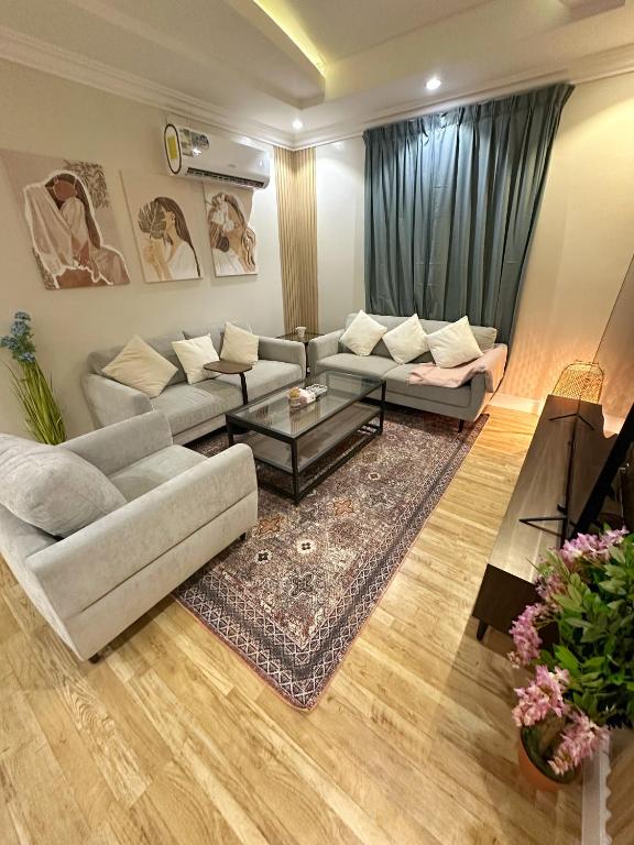 een woonkamer met een bank en een tafel bij شقة جميلة بغرفتين نوم ودخول ذاتي 106B in Riyad