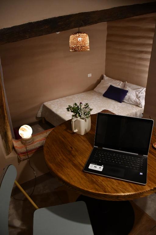a laptop on a table in a room with a bed at La Ventanita de Maima in Maimará