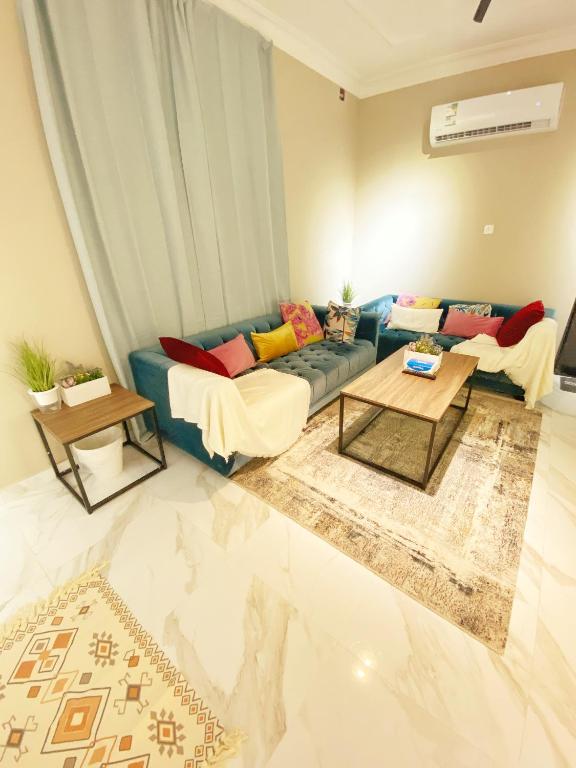 a living room with a blue couch and two tables at Smart Entry Apartment w Pvt Entrance 3B in Riyadh