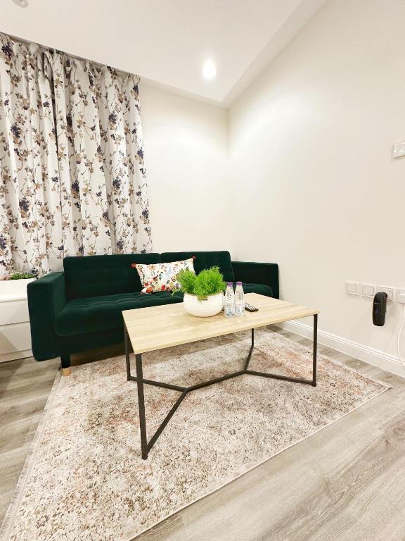 - un salon avec un canapé vert et une table basse dans l'établissement ستوديو أنيق ، مدخل جانبي 101b, à Riyad