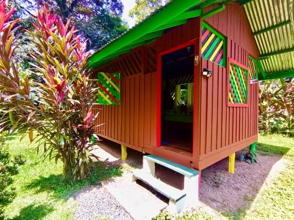 a red play house with stairs in a yard at Alouatta Hanging Bridges Adventure and Lodge in Cahuita