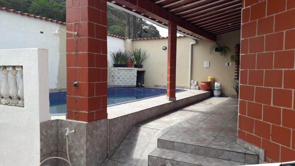 une terrasse avec une piscine dans une maison dans l'établissement Kazapraia, à Mongaguá