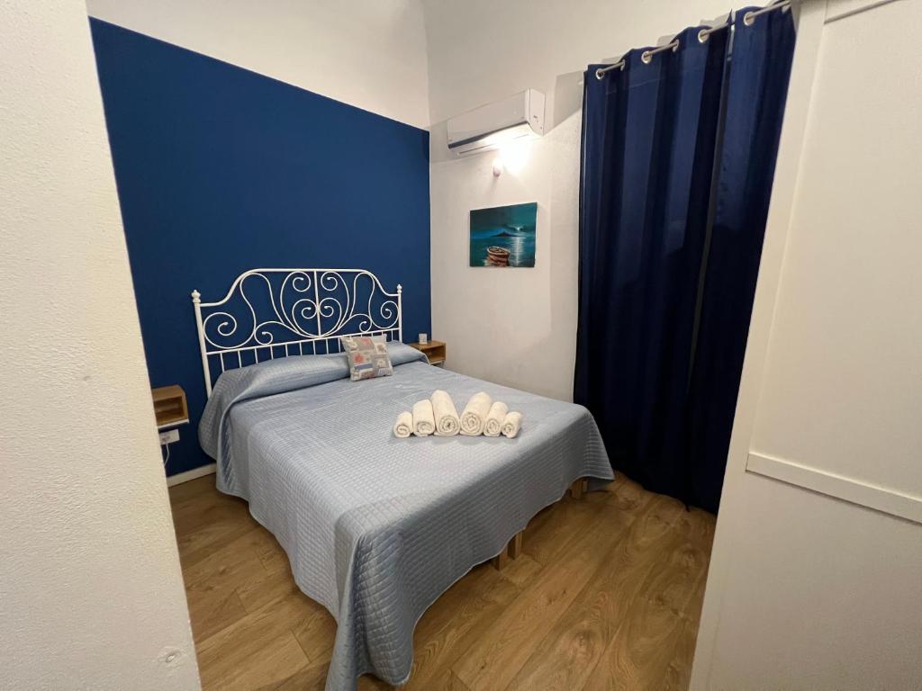 a bedroom with a bed with a blue wall at Ricasoli28 Apartaments in Palermo