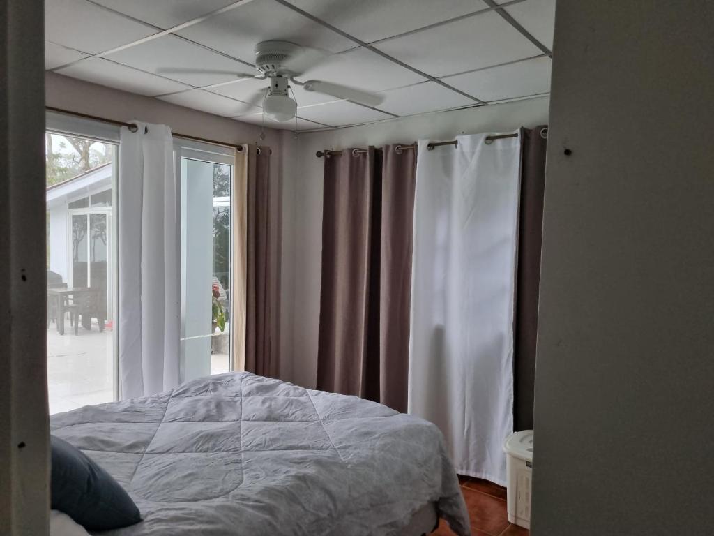 een slaapkamer met een bed en een raam bij Villa Helena in Los Altos de Cerro Azul