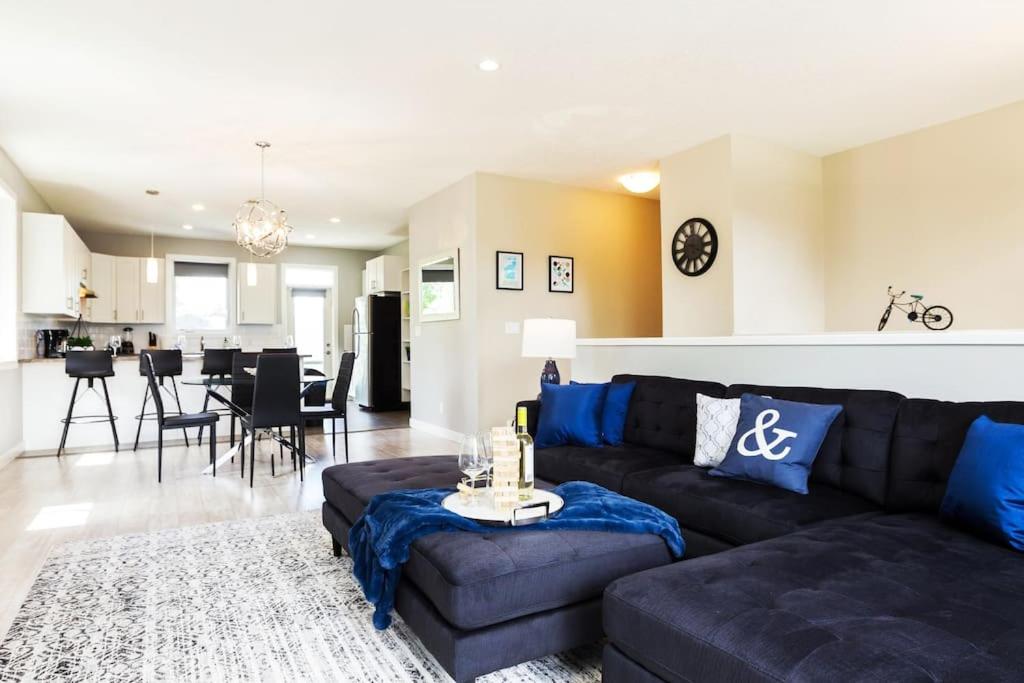 sala de estar con sofá negro y almohadas azules en *Executive Home* Long Stays - Garage - WiFi & NFLX en Edmonton
