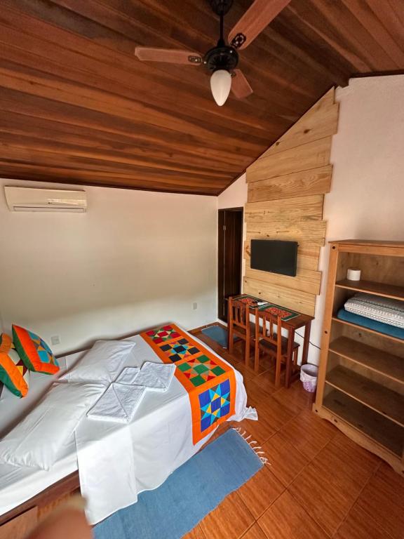NayMar Paraty Casa Familiar في باراتي: غرفة نوم بسرير وتلفزيون بشاشة مسطحة