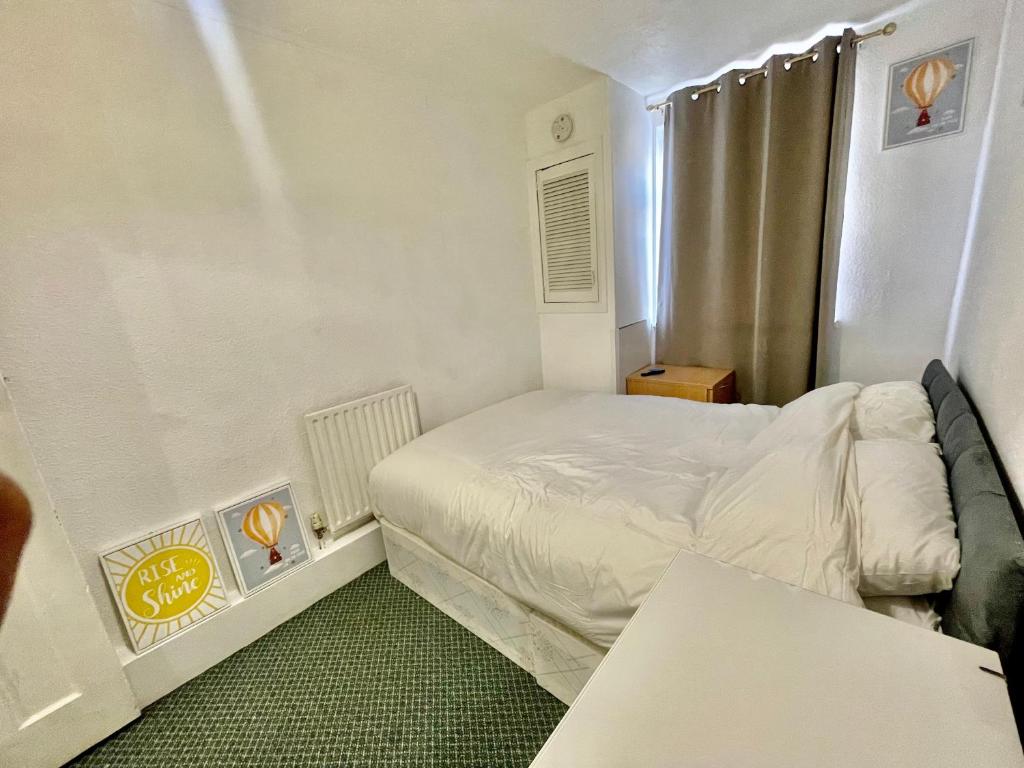 ein kleines Schlafzimmer mit einem Bett und einem Fenster in der Unterkunft Cozy One Bed Apartment Near Purley Station in Purley