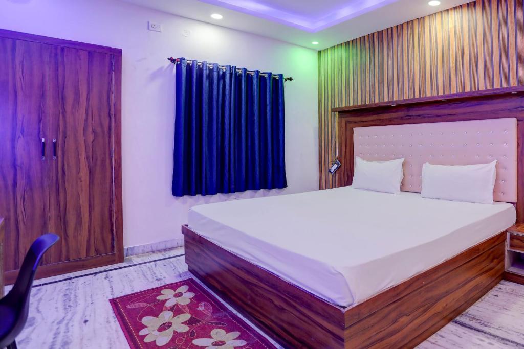 a bedroom with a large bed and a blue curtain at OYO Blue Bell in Patna