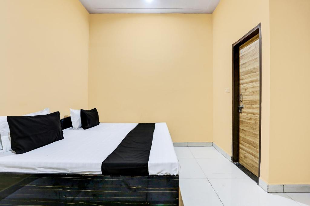 a bedroom with a bed with a black and white comforter at OYO Hotel H.R in Garhi Harsāru