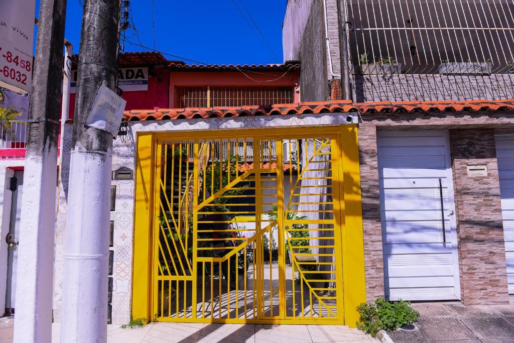 uma porta amarela num edifício com uma escada amarela em Praia de Pajuçara - Kit1 - Castelão Lolla - Maceió em Maceió