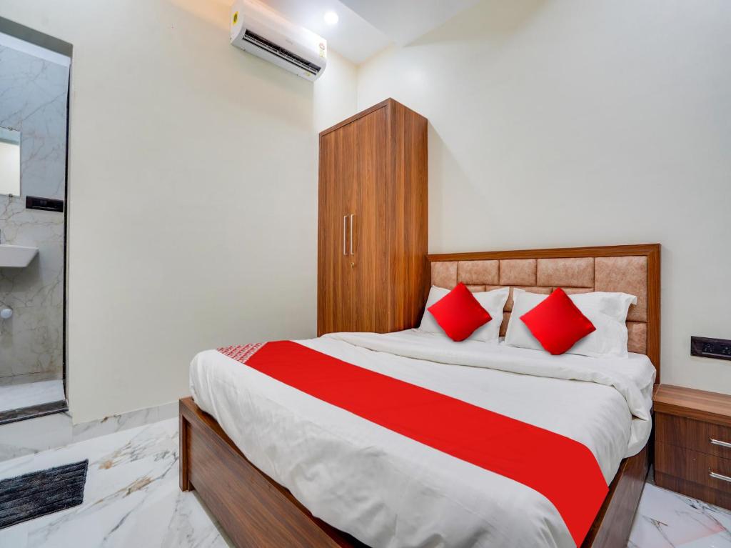 a bedroom with a large bed with red pillows at Hotel RS in Nagpur