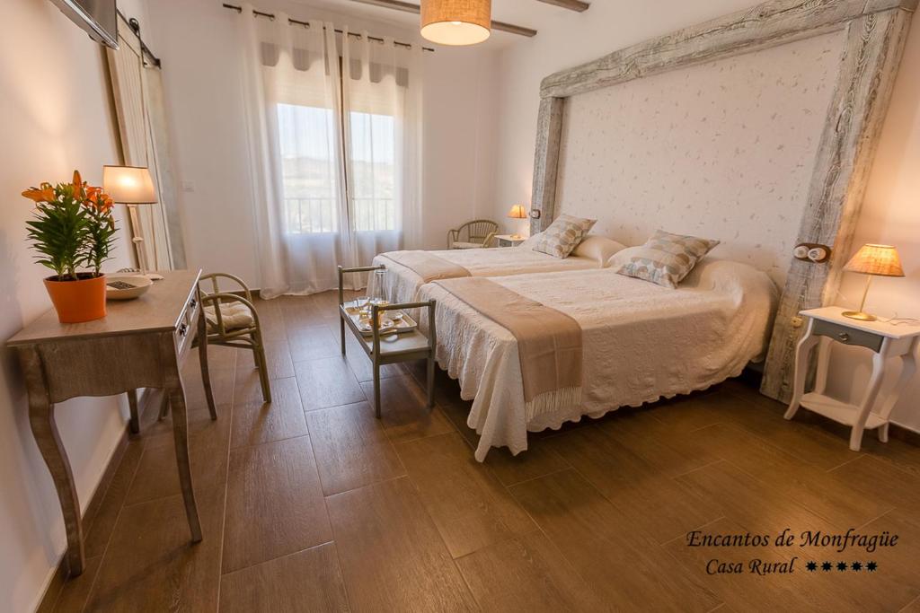 1 dormitorio con 1 cama grande, mesa y sillas en Encantos De Monfragüe, en Malpartida de Plasencia