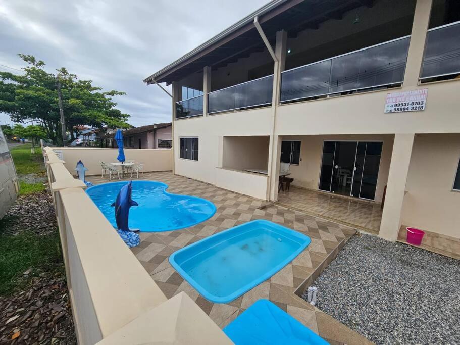 um quintal com duas piscinas e um edifício em Casa de praia com piscina TOP em Paraty