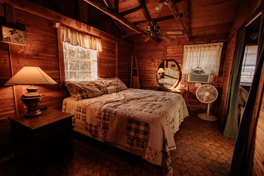 una camera da letto con un letto in una cabina di legno di Thunderbird Lodge a Burnet