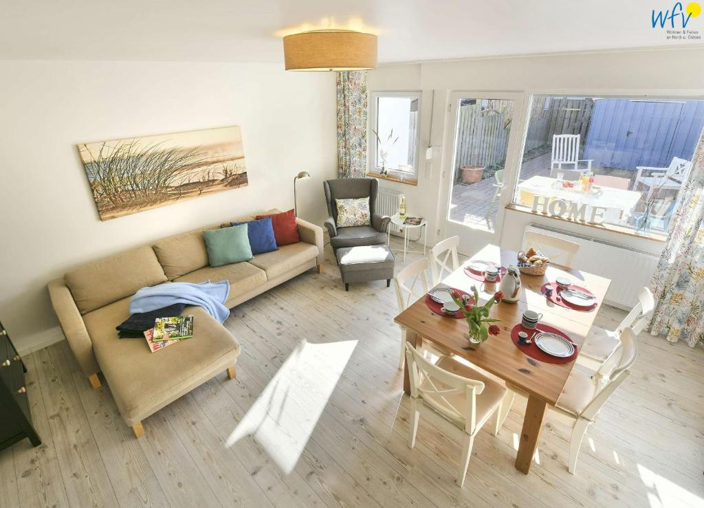 a living room with a couch and a table at Fischerhus Ferienhaus Fischerhus Wangerooge in Wangerooge