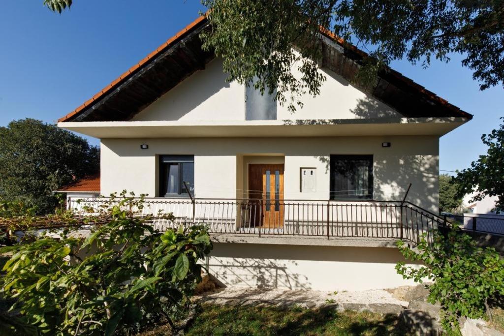 a white house with a porch and a balcony at Holiday house with a parking space Drnis, Zagora - 22772 in Drniš