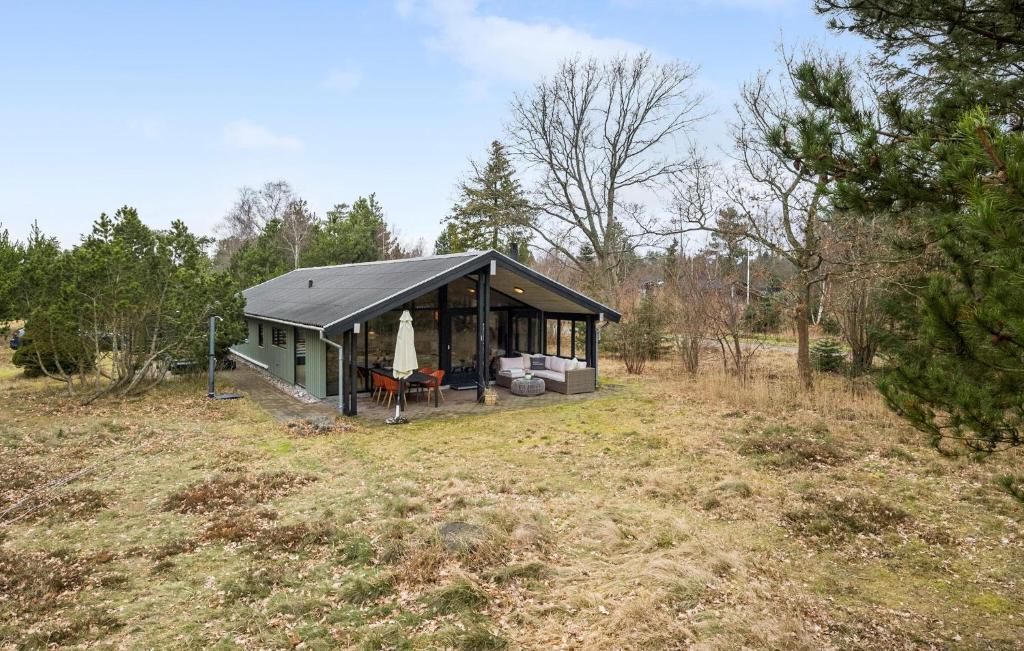a green house with a black roof in a field at Three-Bedroom Holiday Home In Jerup in Jerup
