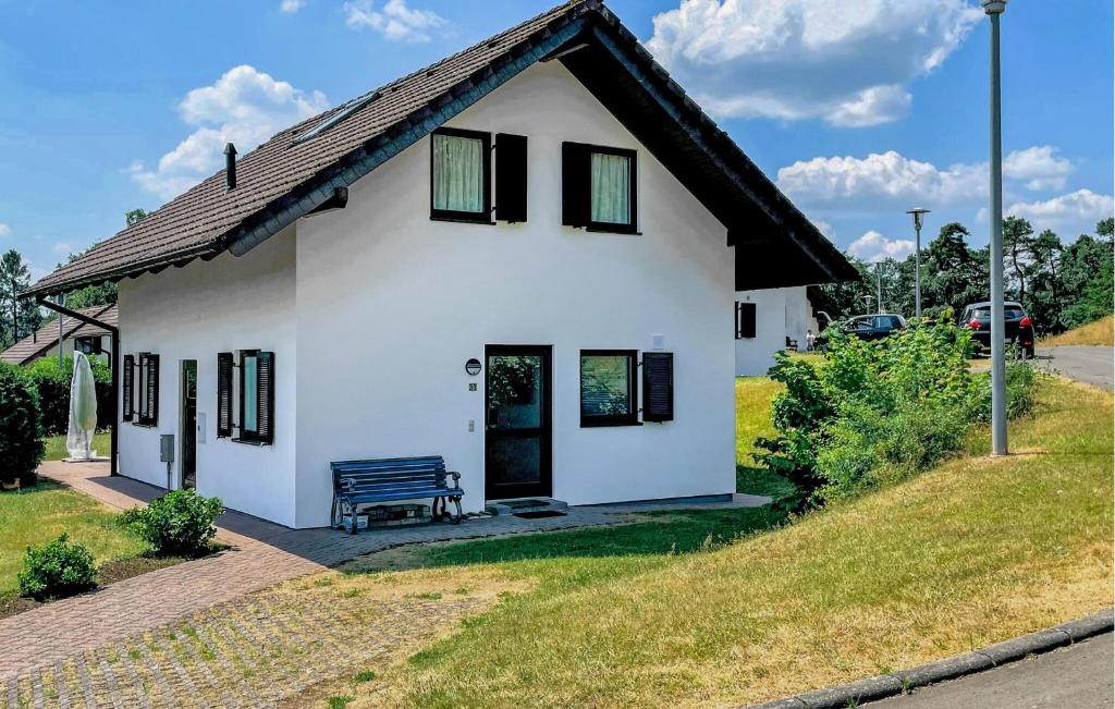 una casa blanca con un banco delante en Ferienhaus 31 In Kirchheim en Kemmerode
