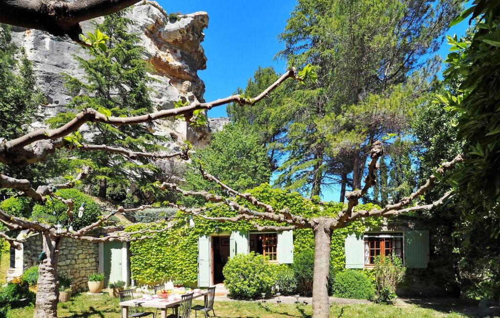 a garden with a table and chairs in front of a house at Les Lauriandes in Les Baux-de-Provence