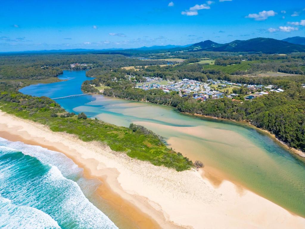 an aerial view of a beach with a town at Valla Beach Holiday Park in Valla Beach