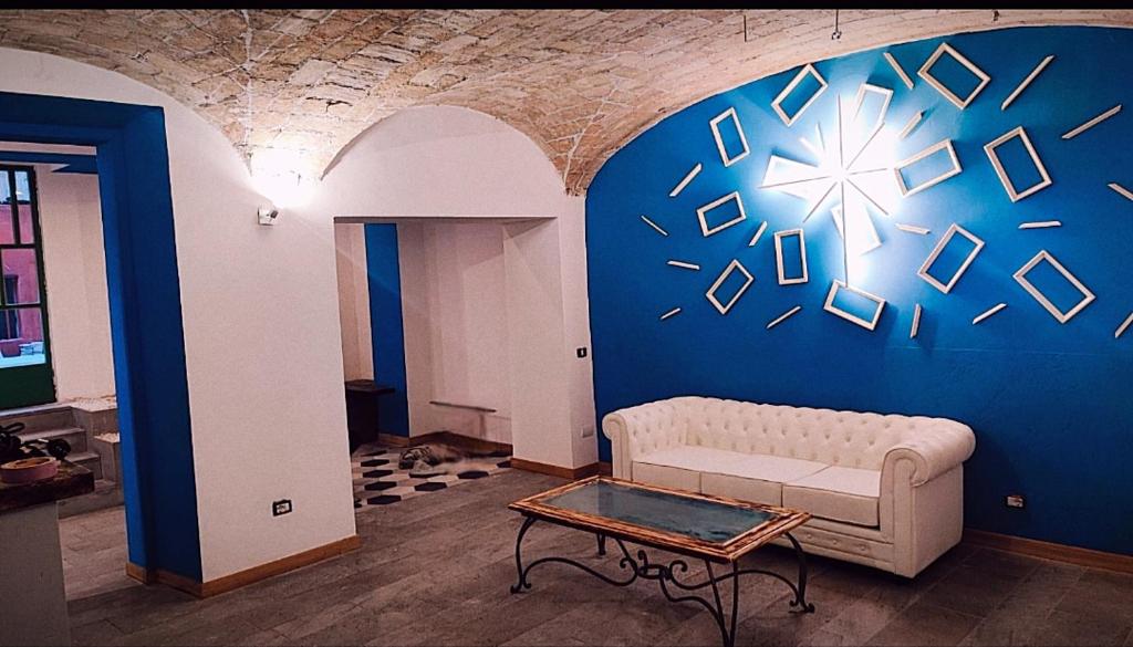 ميتلينغ بوت روما في روما: غرفة معيشة مع أريكة والجدار الأزرق