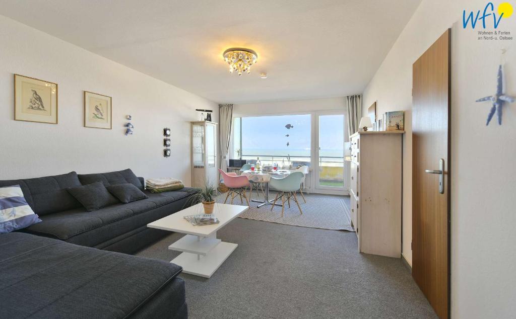 una sala de estar con un sofá y una mesa en Dünenschlösschen Ferienwohnung 10, en Wangerooge