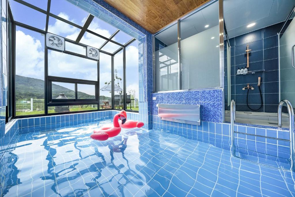 uma piscina com uma bóia vermelha numa casa de banho azul em SkyStarkids poolvilla em Chilgok