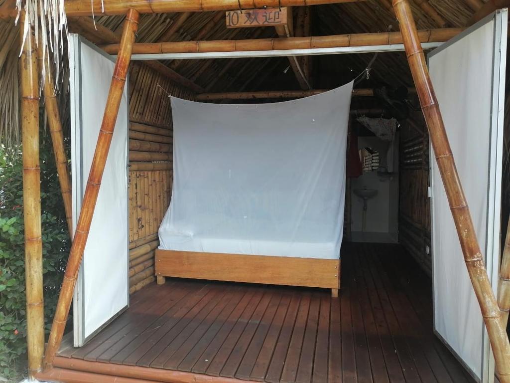 Una pantalla en el porche con una sábana blanca. en Cabaña Beach Palomino, en Palomino