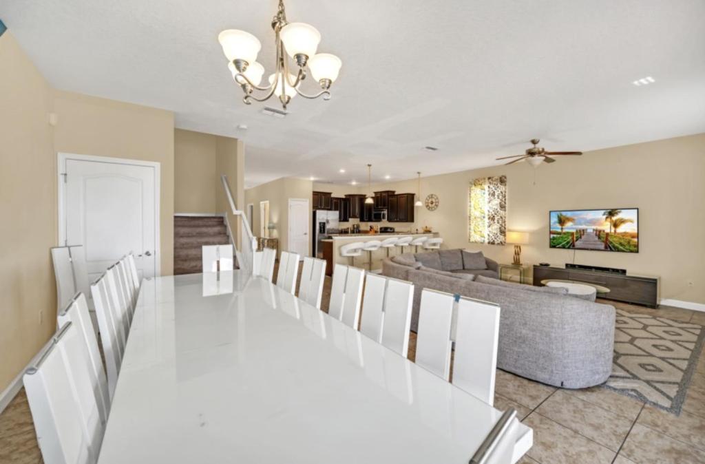 a dining room and living room with a white table and chairs at Elegant Lennar Free Water Park Resort in Kissimmee