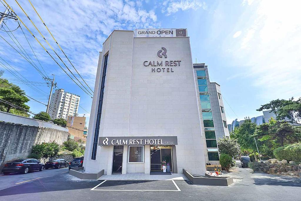 un edificio blanco con un cartel de hotel gourmet en él en Hotel Calmrest, en Geoje