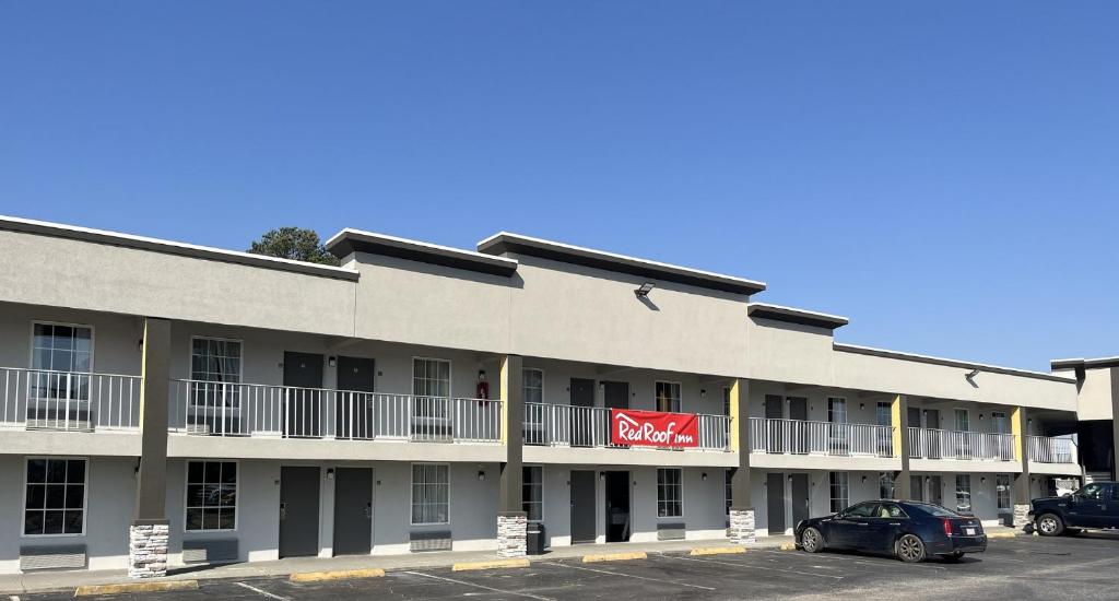 a building with a motel sign on the side of it at Red Roof Inn Dunn in Dunn