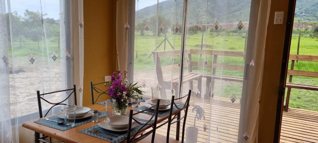 uma sala de jantar com mesa e cadeiras e uma grande janela em Refugio Pucalan Lodge em Puchuncaví
