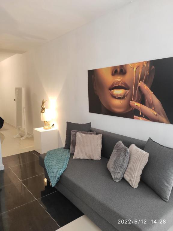 una sala de estar con un sofá con una gran foto en la pared en Winnie's Homestay, en Las Palmas de Gran Canaria