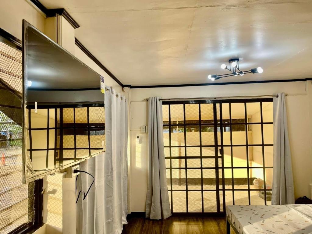 Maria Kulafu Studio Deluxe في ماسبات: غرفة بسرير وباب مع نافذة