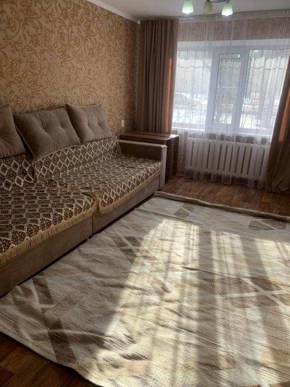 a bedroom with a large bed and a window at трёхкомнатная после ремонта с удобным расположением in Karagandy