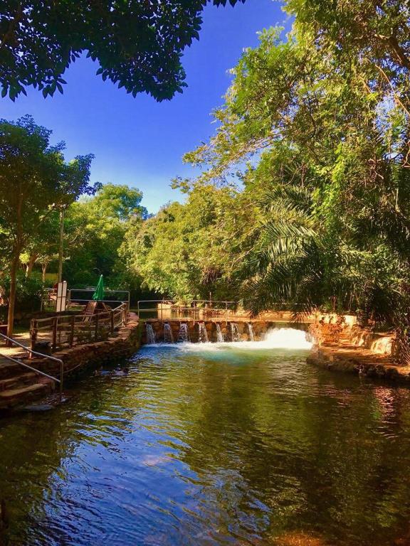 a river with a bridge and a waterfall at thermasparadise Rio quente in Rio Quente