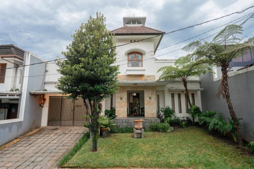 una casa bianca con un albero in cortile di Pasteur Beautiful Luxury Home a Bandung