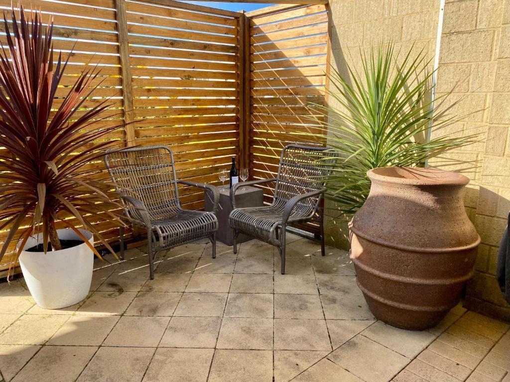 a patio with chairs and a vase and plants at Middleton Bay Retreat in Albany