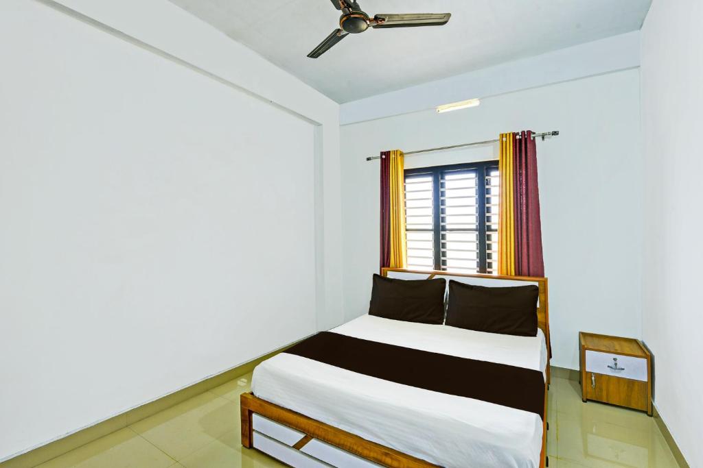 a bedroom with a bed and a window at OYO Blue Sky Apartment in Wayanad
