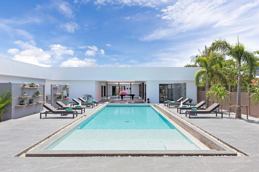 una piscina con tumbonas y una casa en Brand-new 8BR Private Pool Villa Mystic Garden, en Rawai Beach