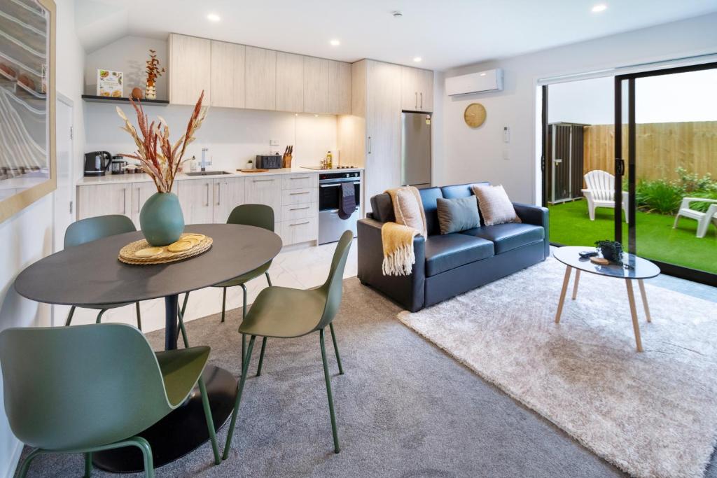 a kitchen and living room with a table and chairs at Elegant 2 Bed 2 Bath Home in the CBD in Christchurch
