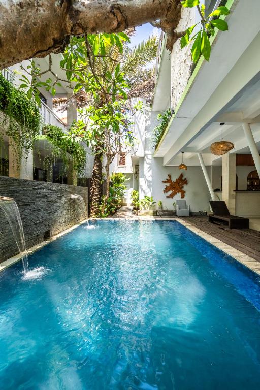 an indoor pool with blue water in a building at Casa Dasa Legian in Seminyak