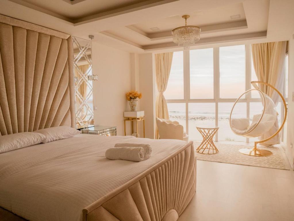 a bedroom with a large bed and a large window at Beachfront Seaview Apartment in Male City