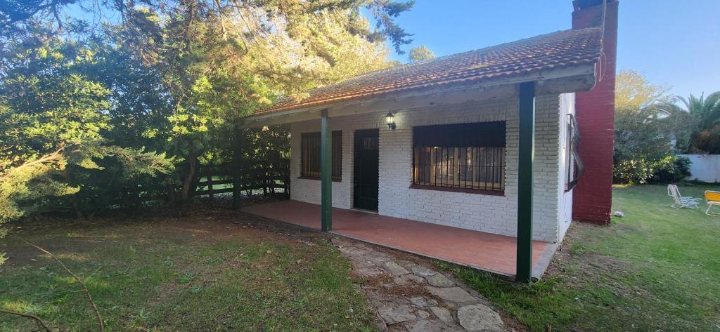 Cette petite maison blanche dispose d'une terrasse en bois. dans l'établissement Casa rustica en Mar Chiquita, à Balneario Mar Chiquita