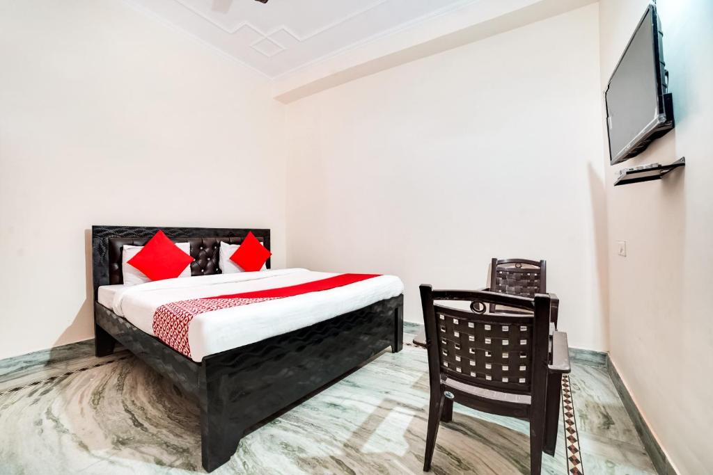 1 dormitorio con 1 cama, TV y silla en Shree Golju Palace, en Pantnagar